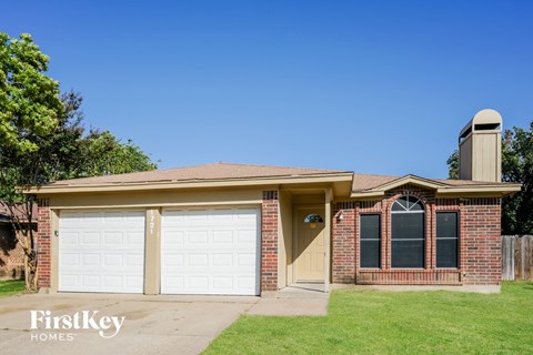 A brick house with a garage and a chimney.