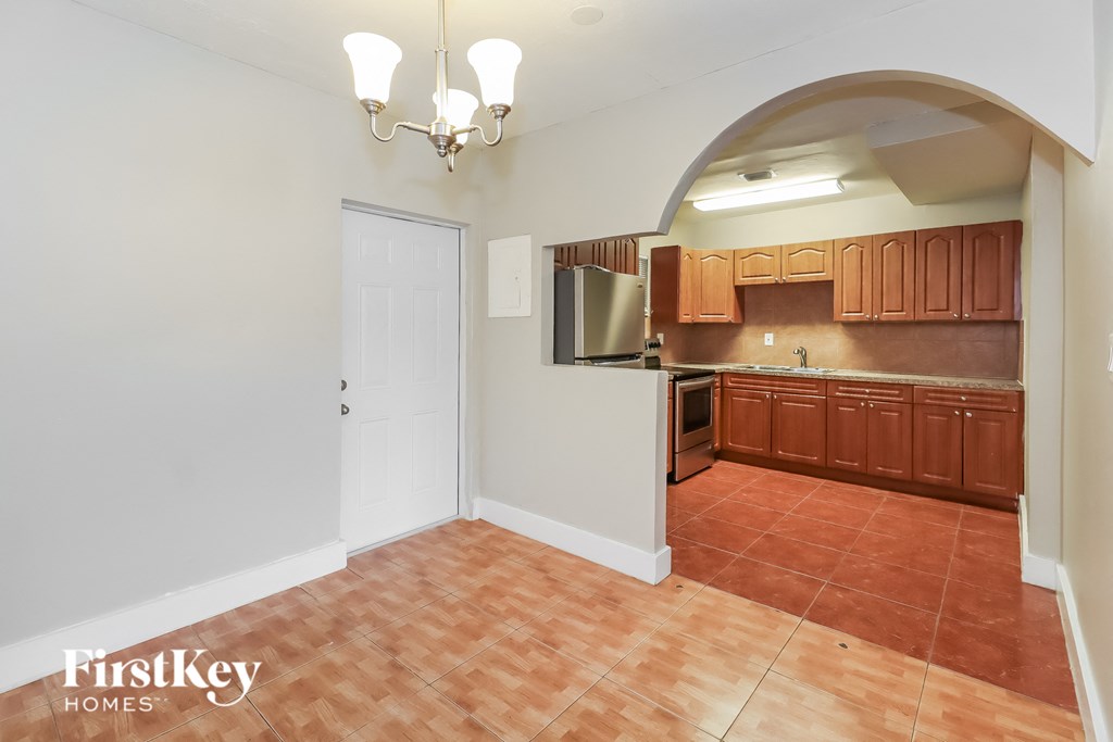 an empty kitchen with wooden cabinets and a white door