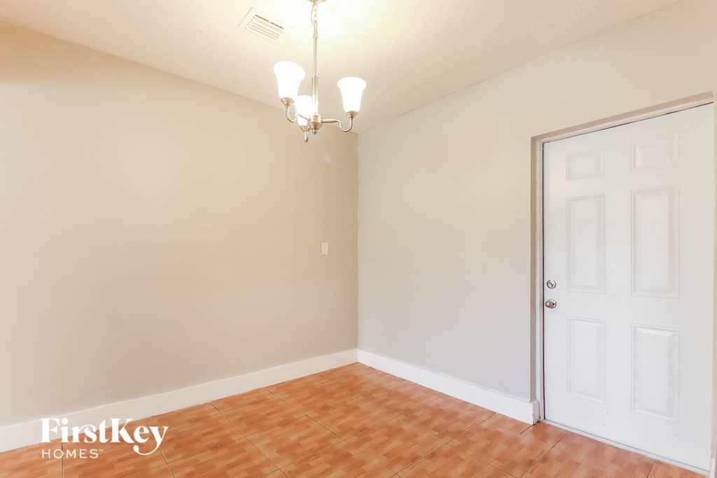 a living room with a white door and a wooden floor