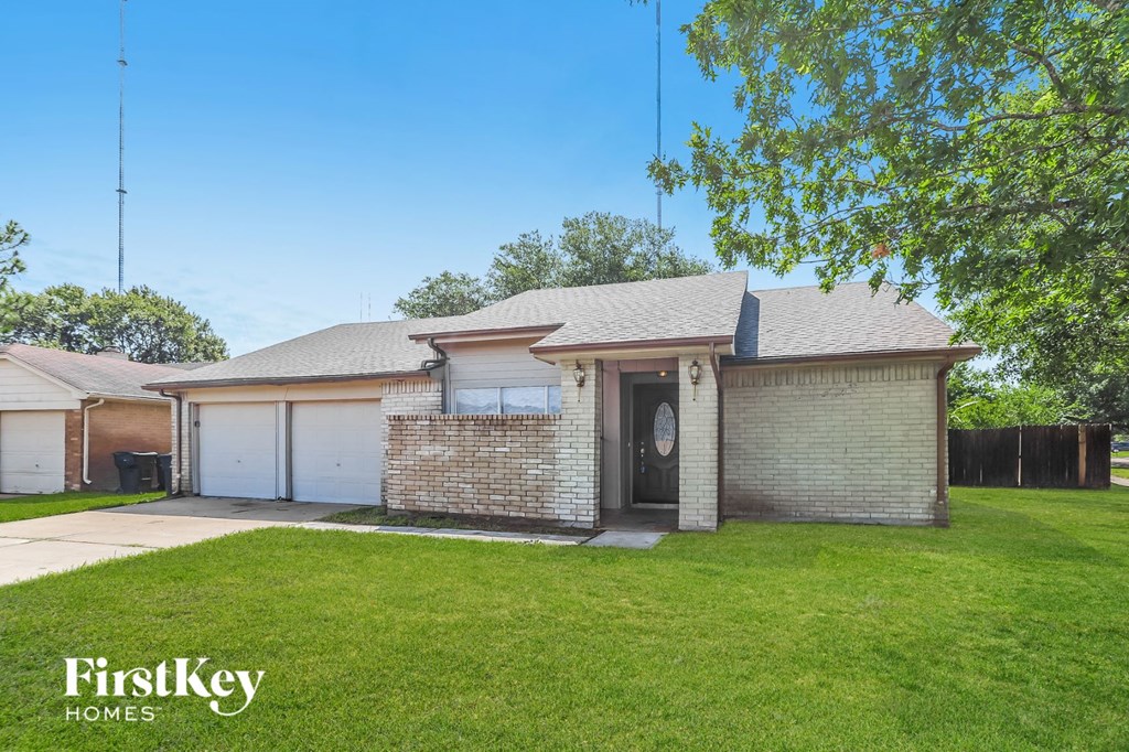 a brick house with a lawn and a driveway