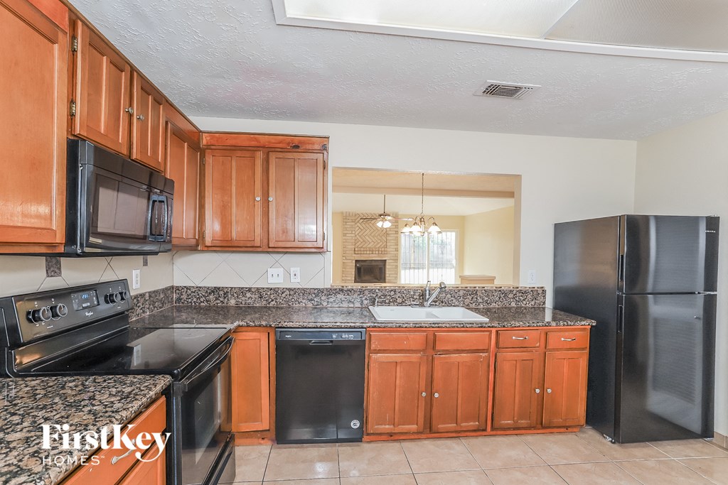 a kitchen with granite counter tops and black appliances