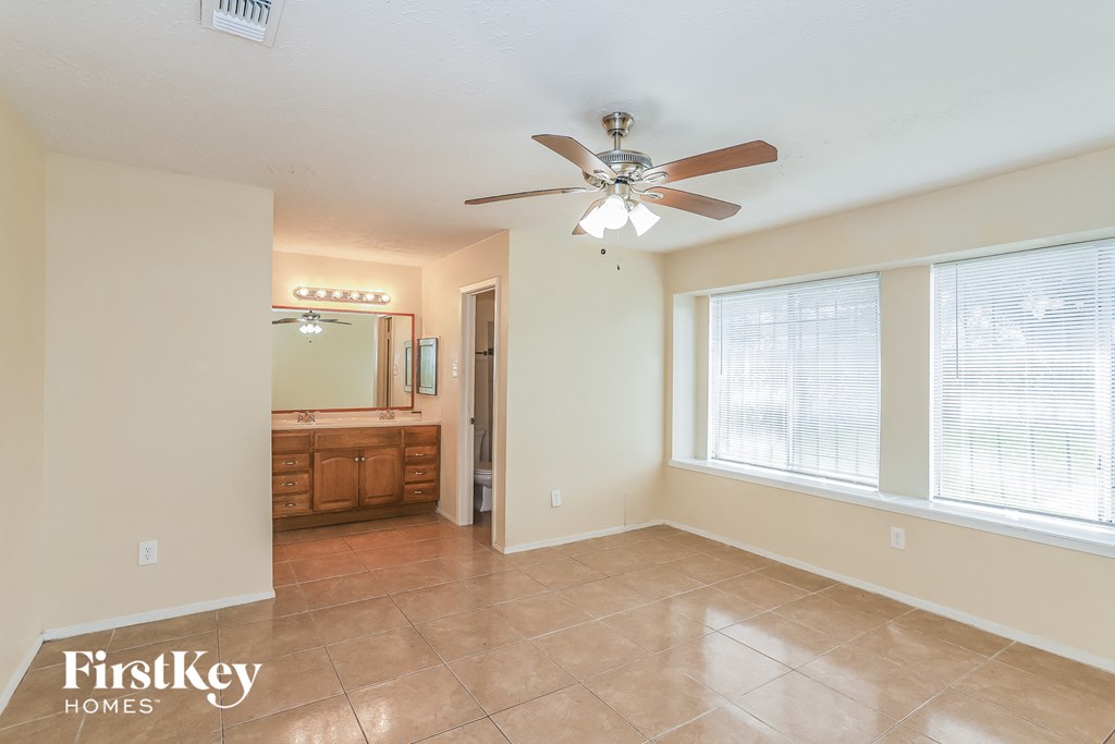 a living room with a ceiling fan and a large window