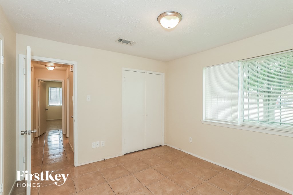 a living room with a tile floor and a door to a hallway