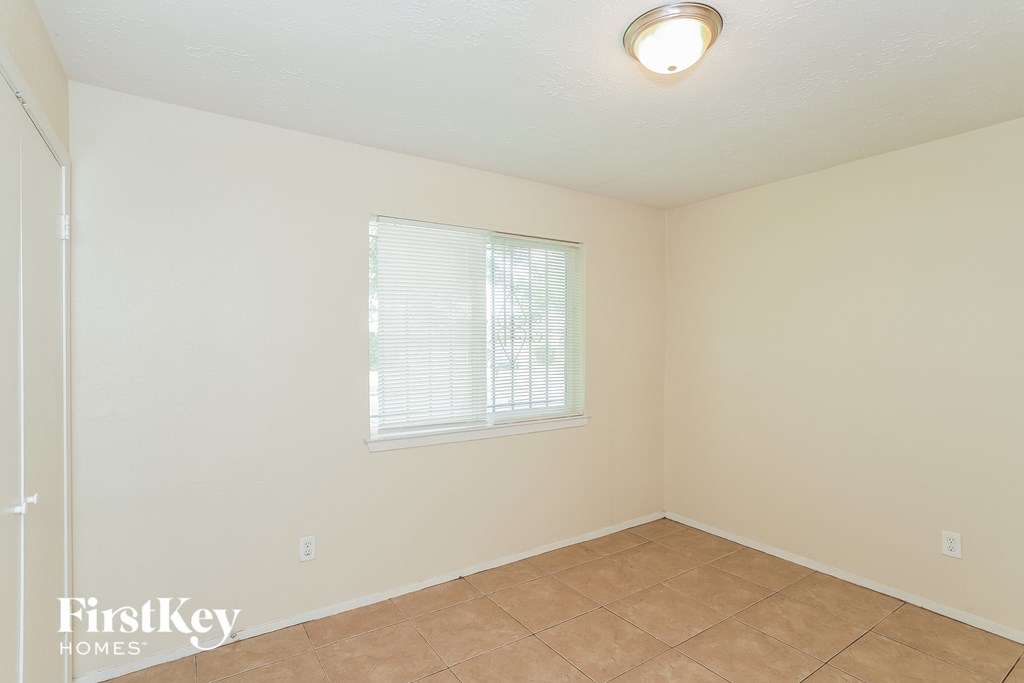 an empty room with a window and a tiled floor