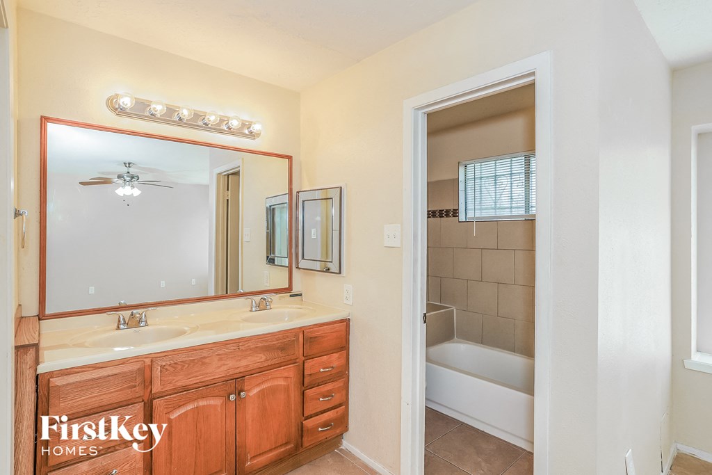 a bathroom with a sink and a mirror and a shower and a toilet