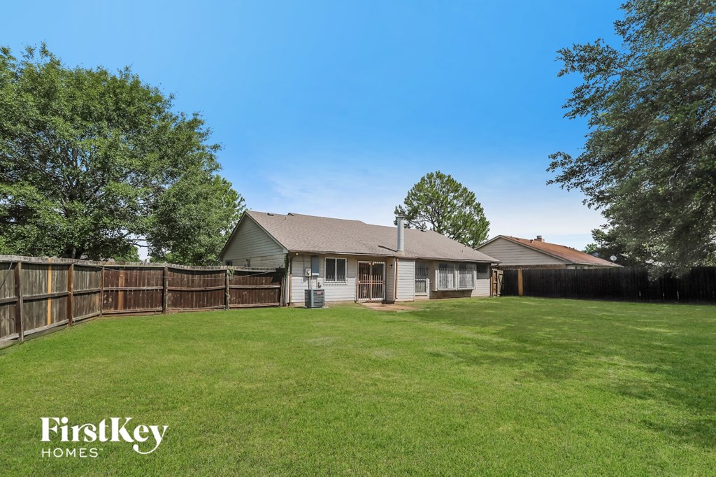 a backyard with a fence and a house