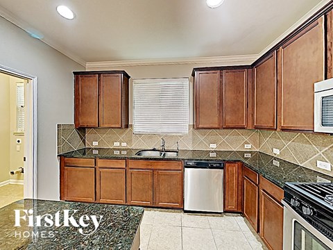 A kitchen with wooden cabinets and a granite countertop.