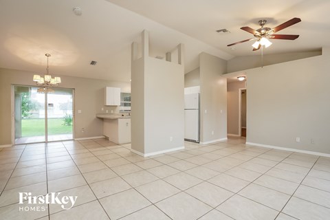 an empty kitchen and living room with a ceiling fan