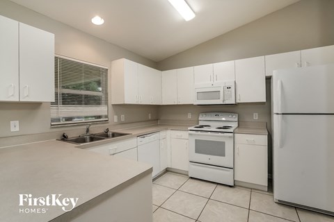 a white kitchen with white appliances and white cabinets
