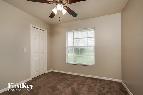 a bedroom with a ceiling fan and a window
