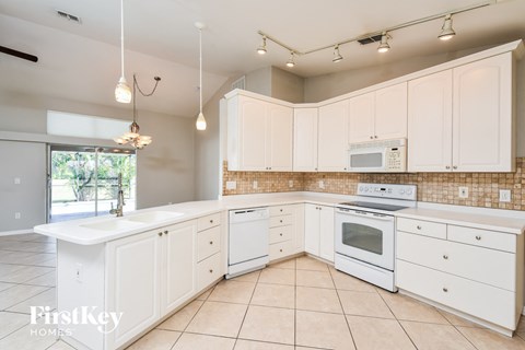 a white kitchen with white appliances and white cabinets