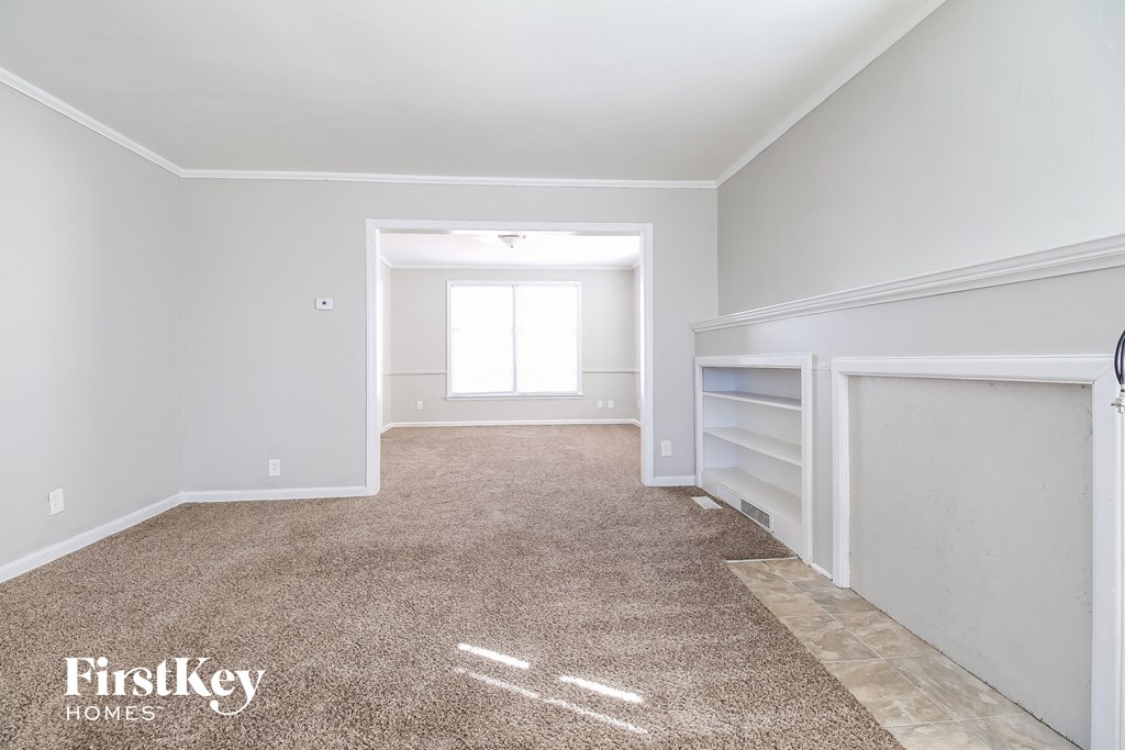 a bedroom with a carpeted floor and a closet with white walls and a window