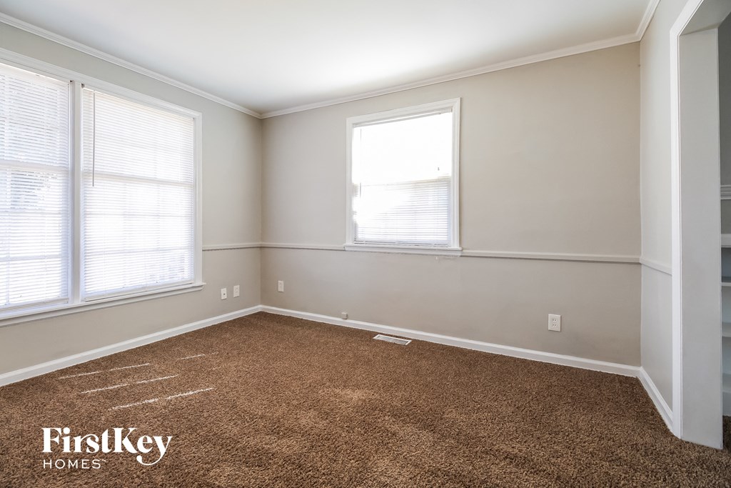 a bedroom with a carpeted floor and two windows