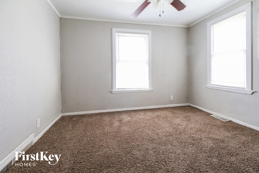 a bedroom with a carpeted floor and two windows