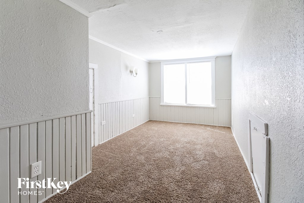 an empty room with a carpeted floor and a window