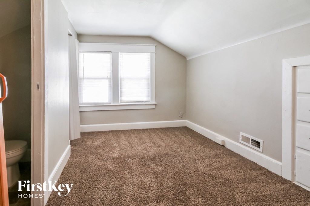 a bedroom with a carpeted floor and a window