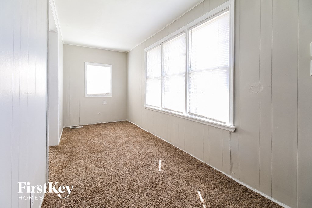 a bedroom with a carpeted floor and three windows
