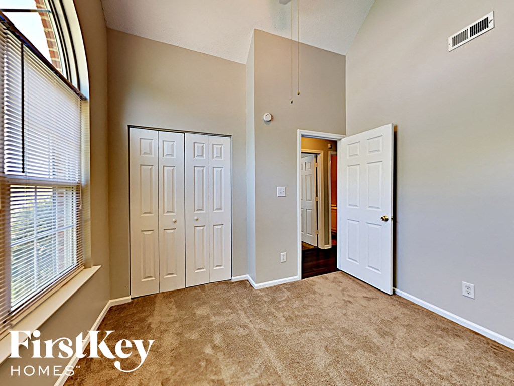 an empty living room with two doors and a window