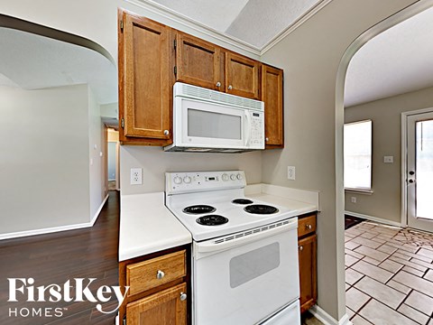 a kitchen with a white stove and microwave and wooden cabinets