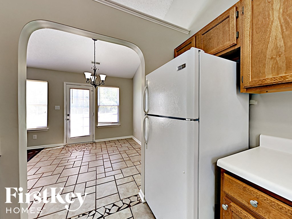a kitchen with a white refrigerator and wooden cabinets