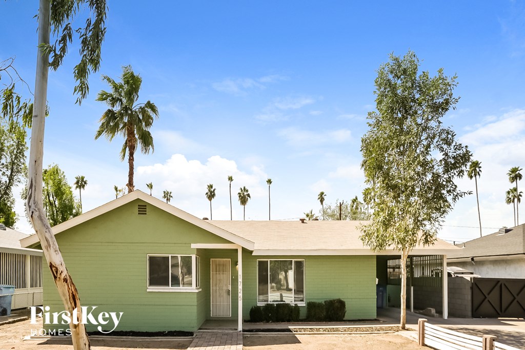 a green house with palm trees and a blue sky