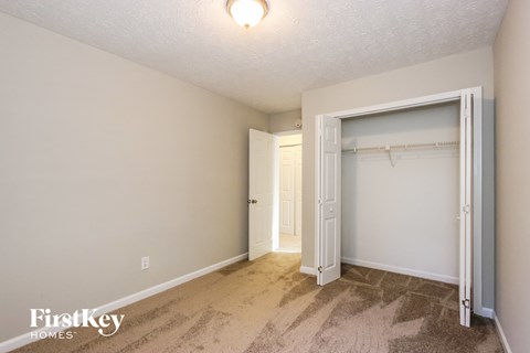 a bedroom with a closet and a door to a bathroom