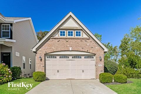 A house with a garage door and a brick wall.