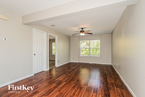 A room with wooden floors and a ceiling fan.