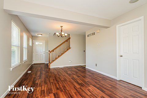 A room with wooden floors and a staircase.