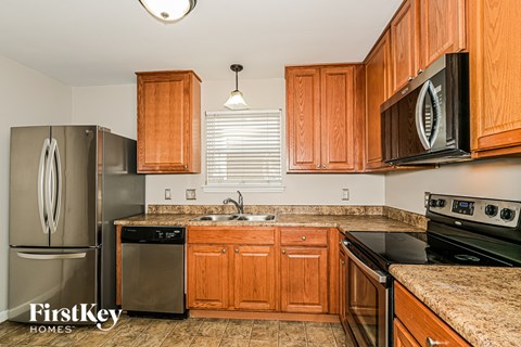 A kitchen with wooden cabinets and a stove top oven.