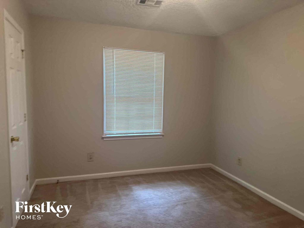 a small room with a window and a wooden floor
