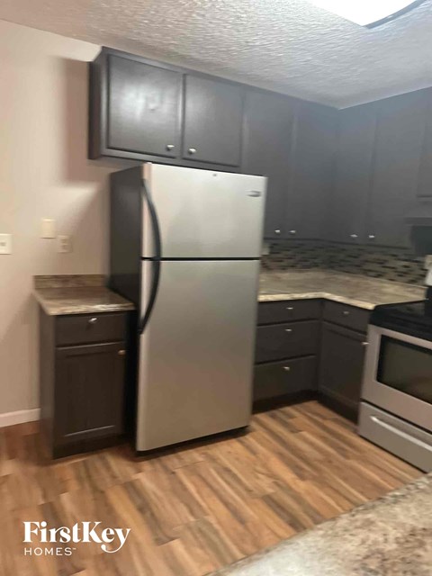 a kitchen with a stainless steel refrigerator and black cabinets
