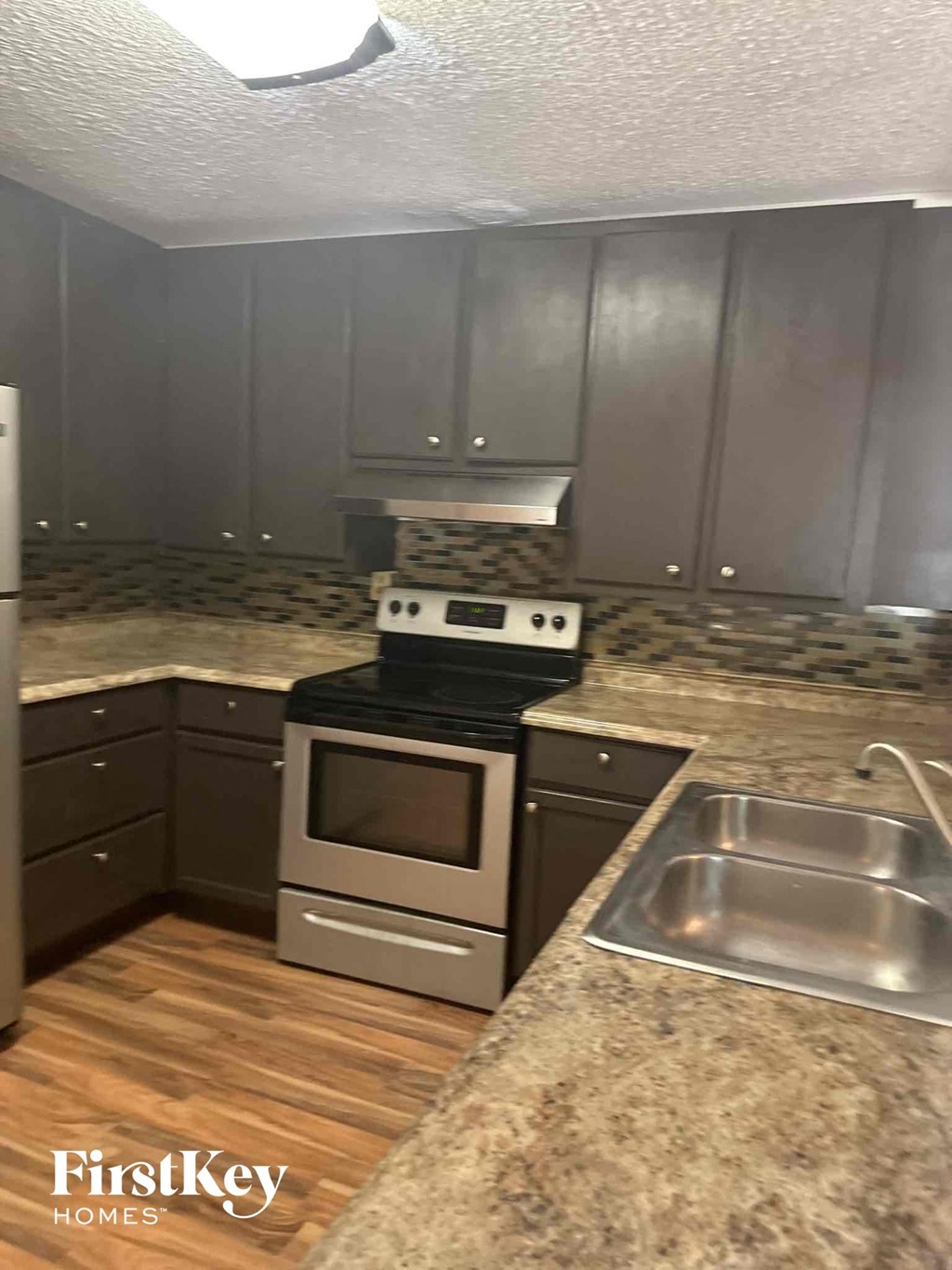 an updated kitchen with granite counter tops and stainless steel appliances