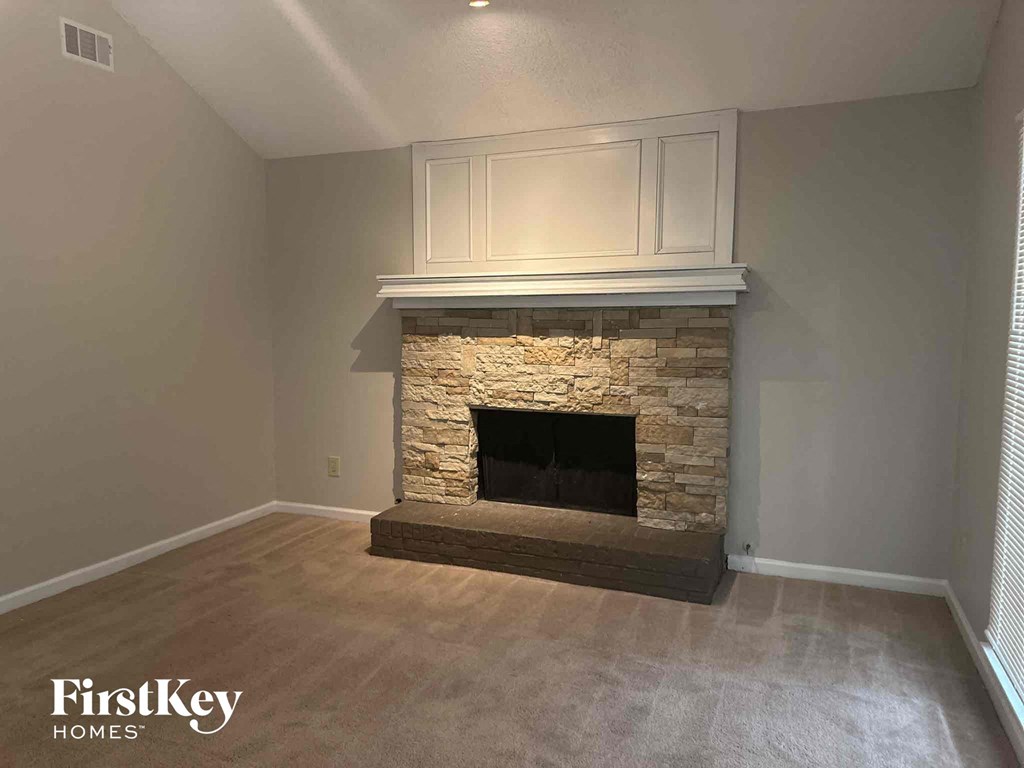 a stone fireplace with a white mantel in a living room