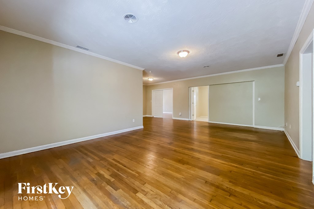 the living room and dining room of an empty house with wood flooring