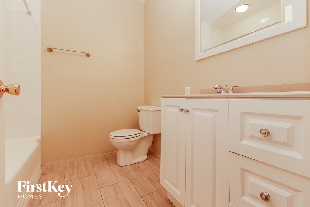 a bathroom with a toilet and a sink and a mirror