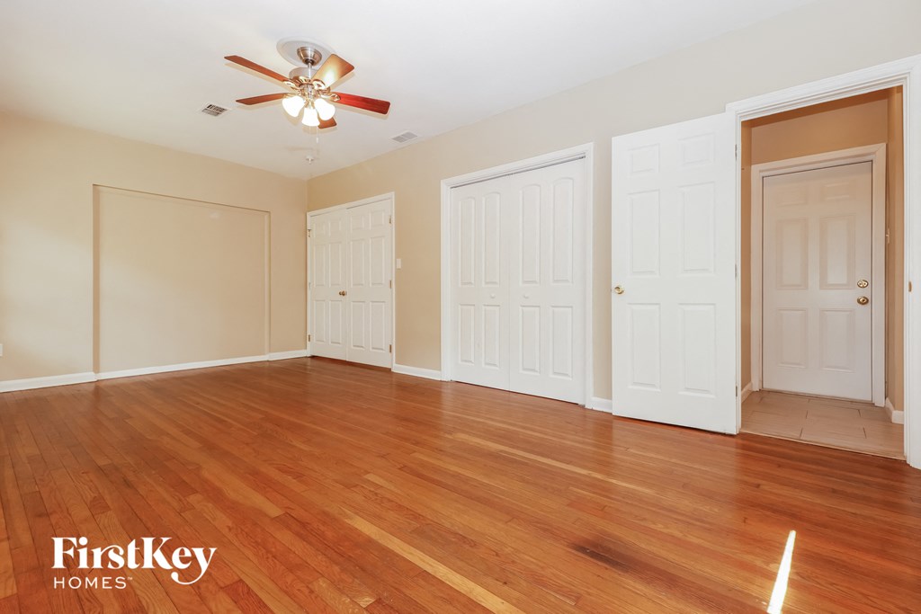 a living room with wood floors and a ceiling fan