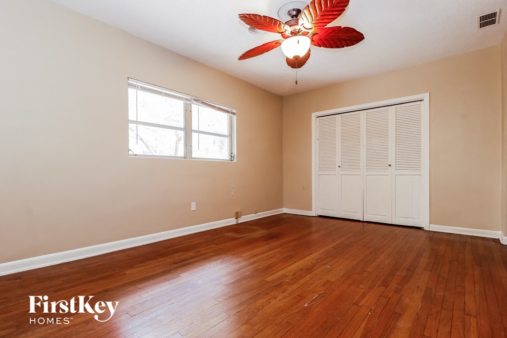 a living room with wood floors and a ceiling fan