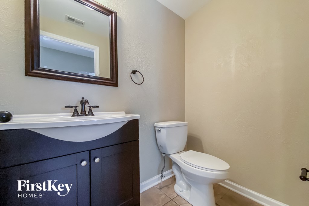 a bathroom with a toilet and a sink and a mirror