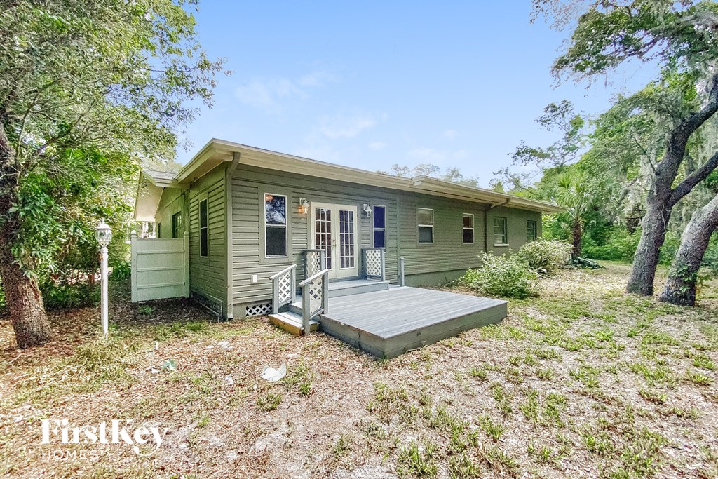 a green house with a porch and a deck