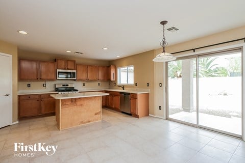 a large kitchen with wooden cabinets and a sliding glass door