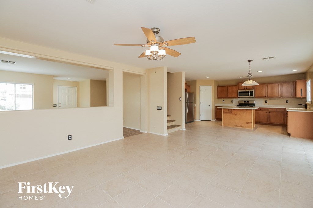 an empty kitchen and living room with a ceiling fan