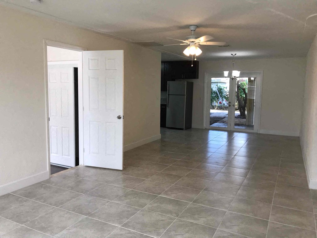A room with a ceiling fan and tile flooring.