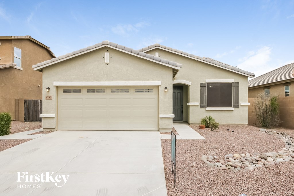 A house with a garage and a driveway in front of it.