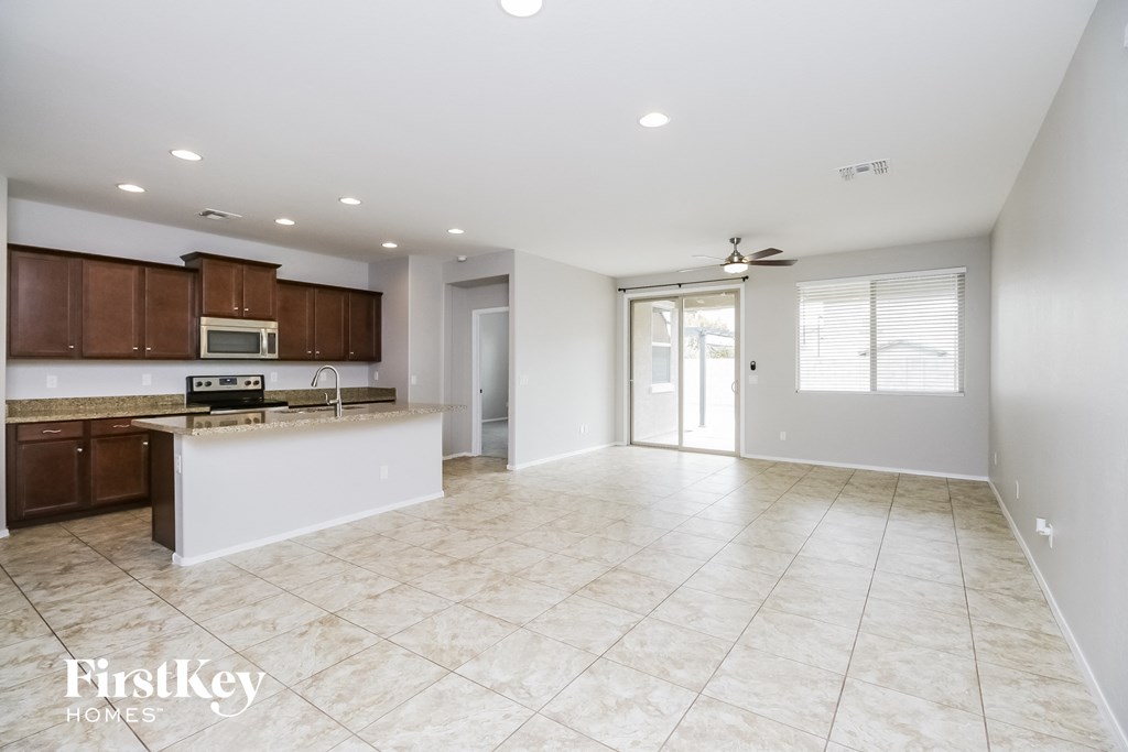 A spacious kitchen and living room with a marble floor.