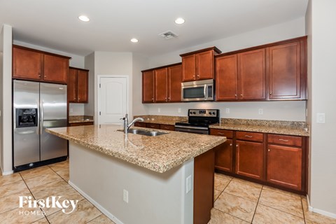 A kitchen with brown cabinets and a granite countertop.