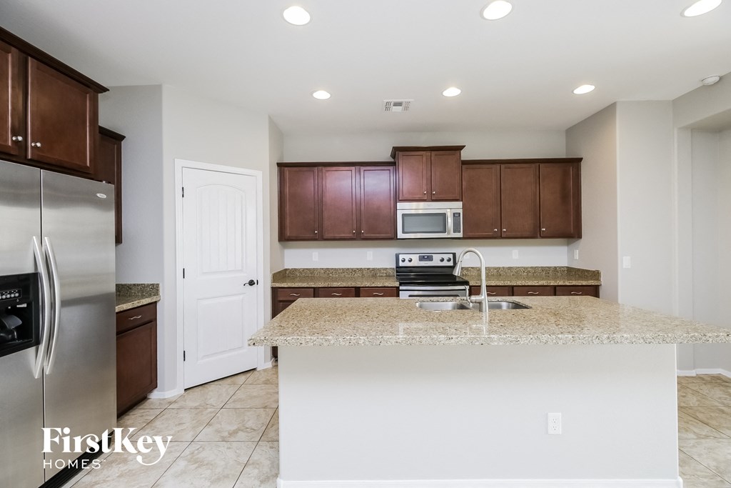 A kitchen with a white island and brown cabinets.