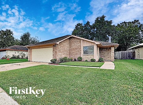 a small brick house with a lawn in front of it