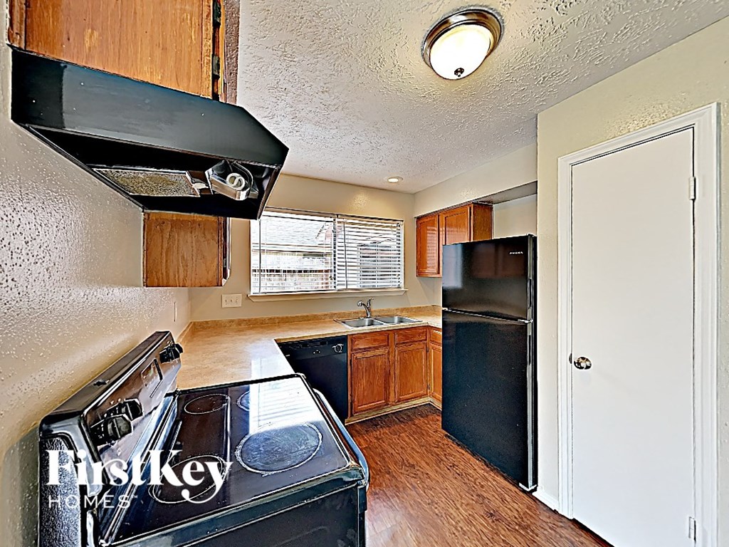 an empty kitchen with a stove and a refrigerator