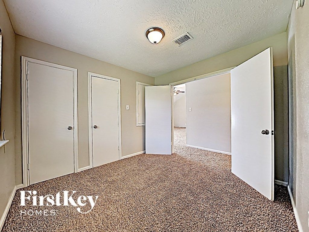 an empty room with five doors and a carpeted floor